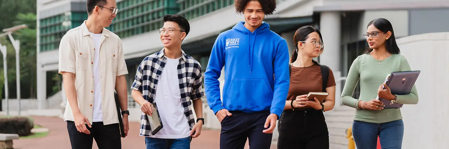 Five students walking on Heriot-Watt University Malaysia campus.