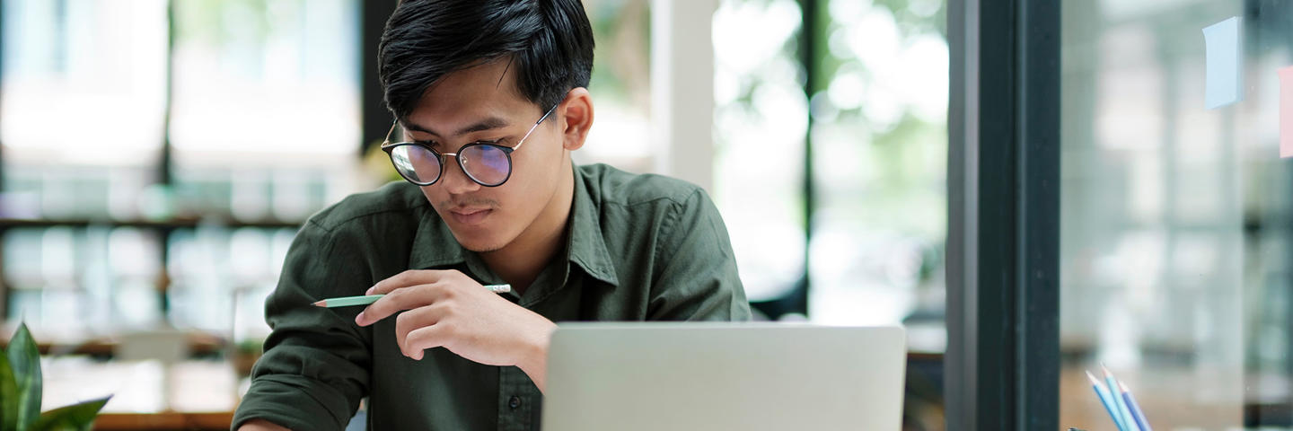 Student works on a laptop reviewing documents.
