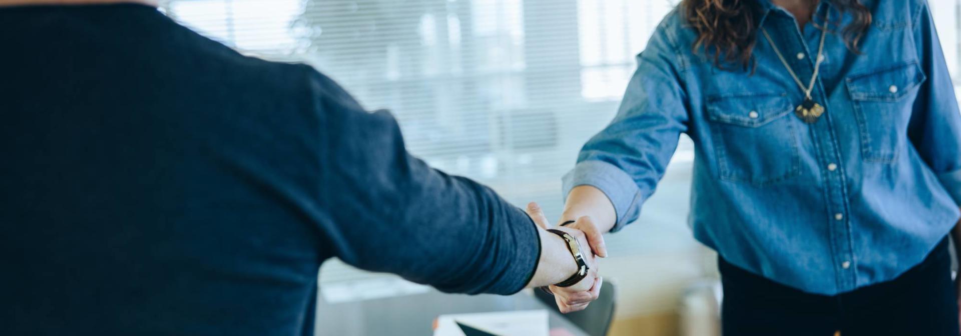 Two people meet and shaking hands.