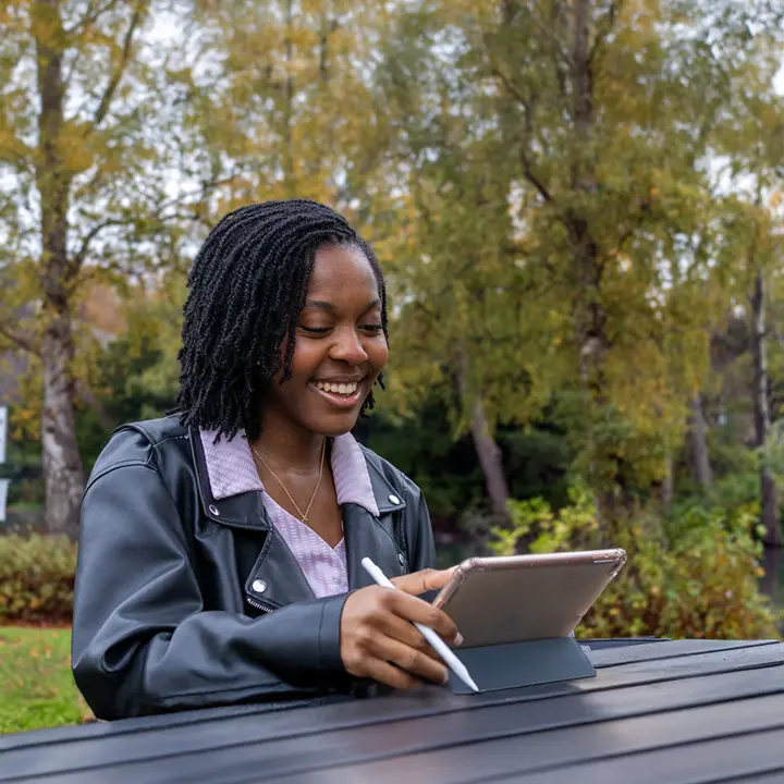 Naomi, architectural engineering student, working on ipad in front of the loch