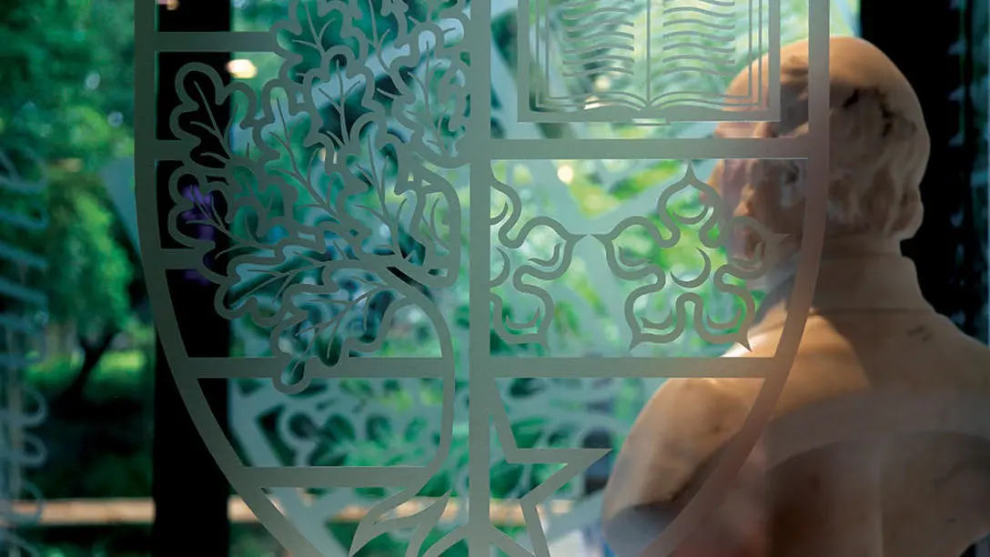 Bust of James Watt viewed through a glass door with Heriot-Watt crest imprint