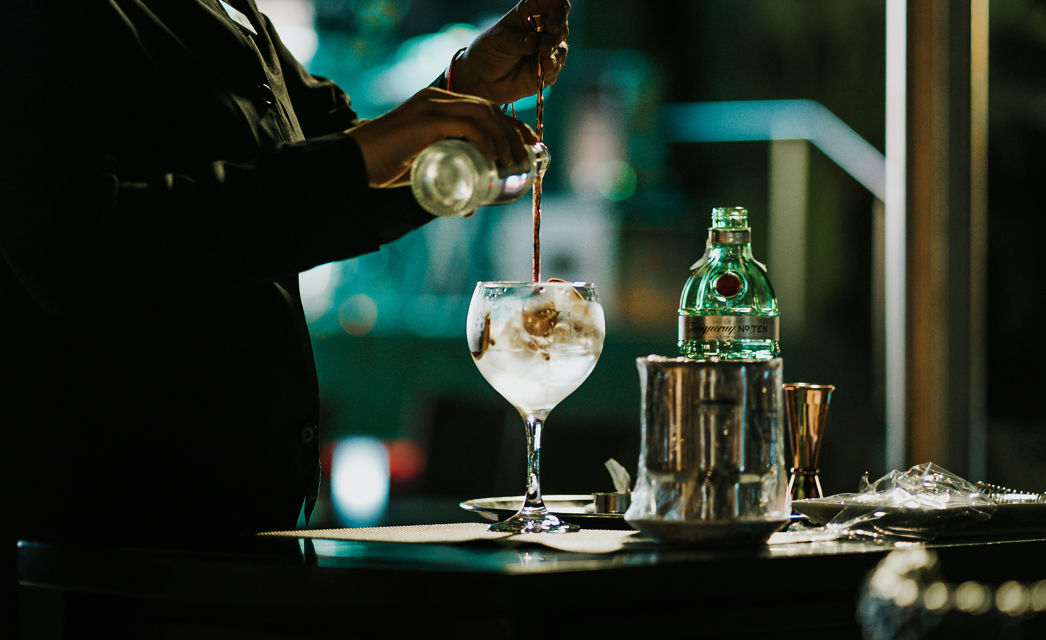 Pouring a gin. Photo by Bjarne Vijfvinkel on Unsplash.