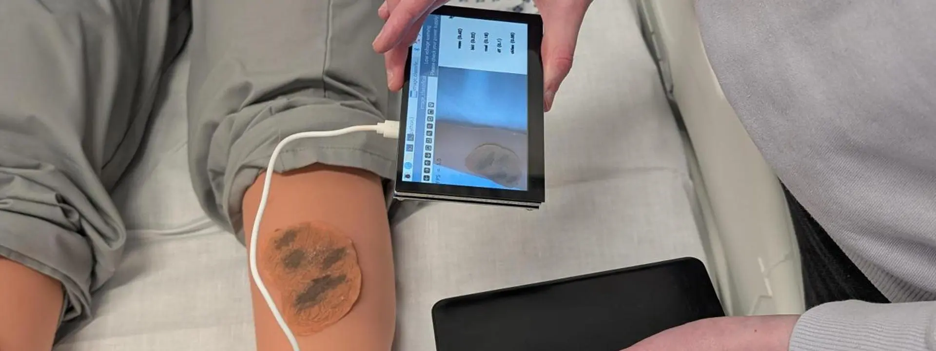 Images shows the handheld device being tested on an artificial leg.