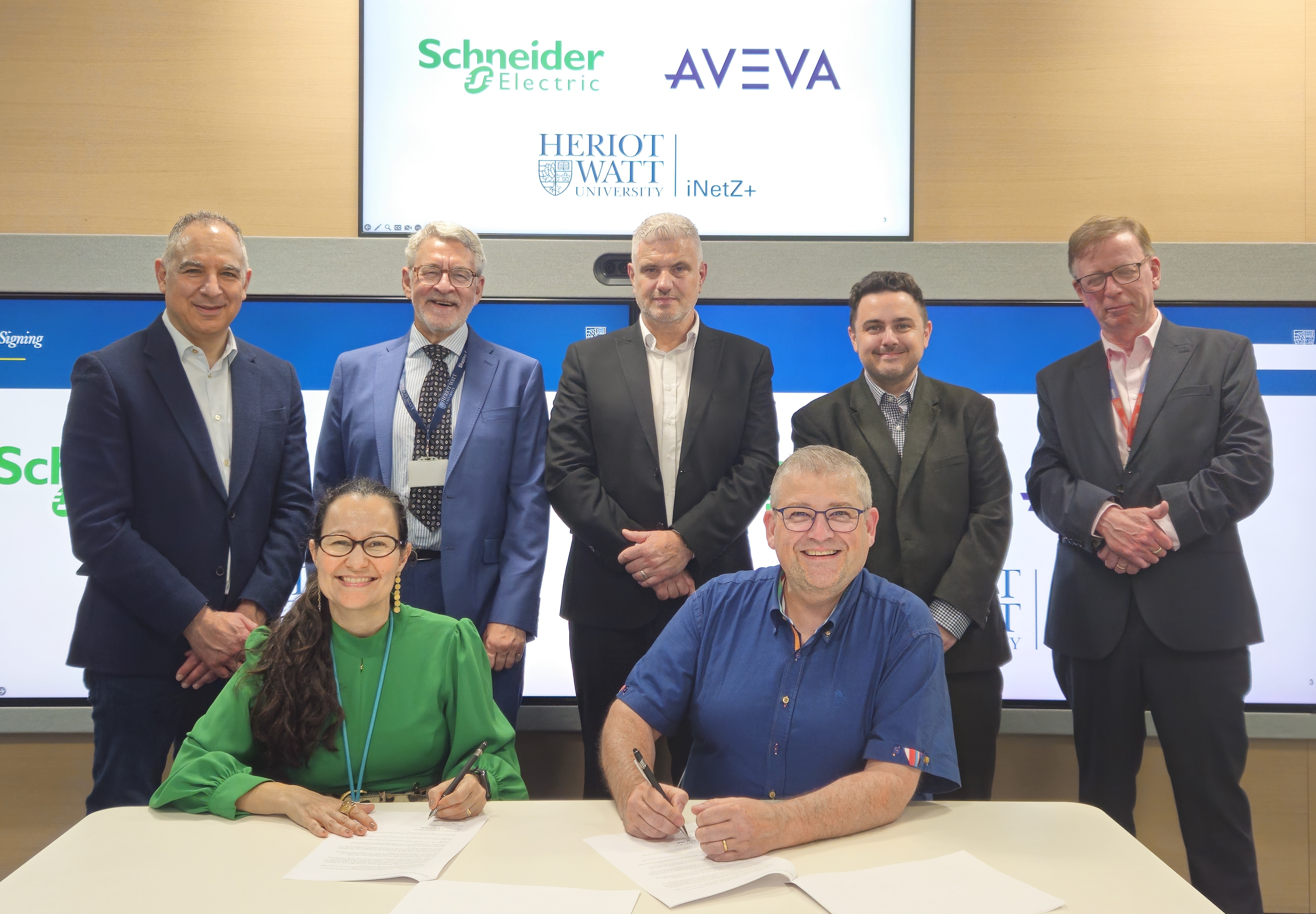 A group of people from companies Schneider Electric, Aveva and Heriot-Watt University signing an MoU agreement 