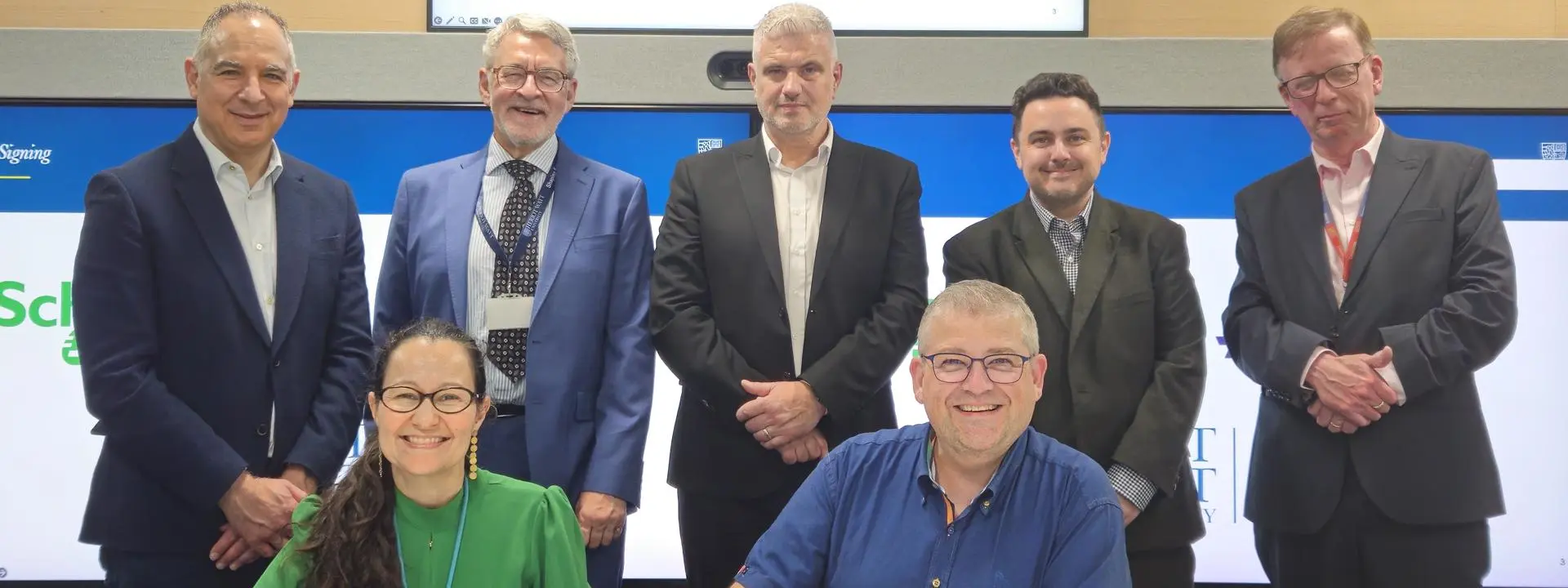 A group of people from companies Schneider Electric, Aveva and Heriot-Watt University signing an MoU agreement
