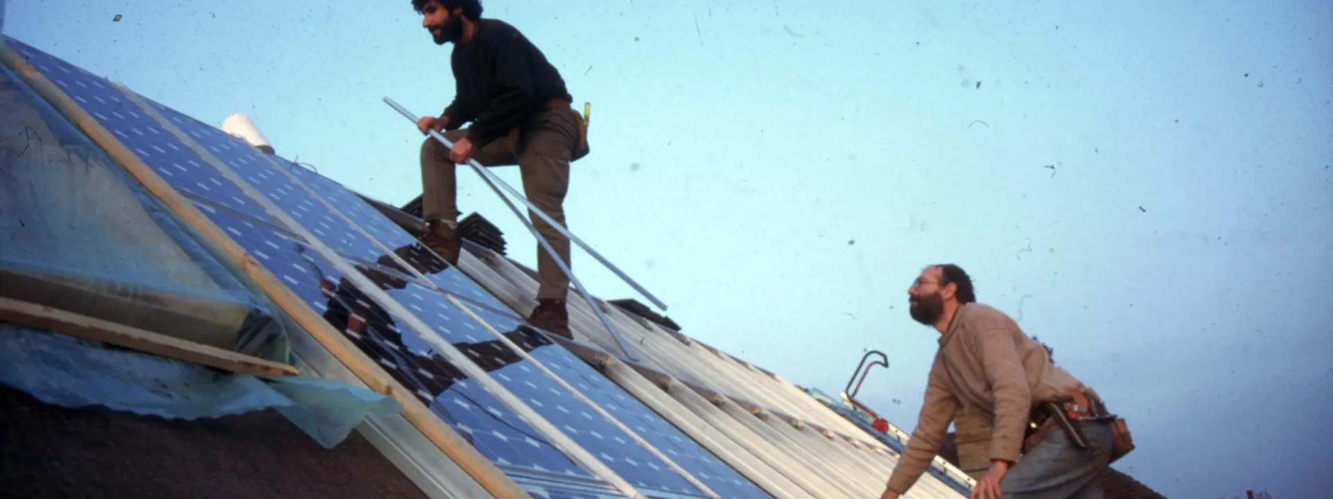Image shows two workmen working on the solar roof 30 years ago.