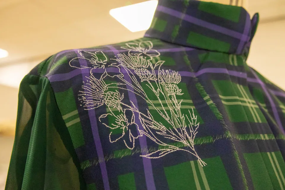 A detail of Kayleigh’s tartan, with embroidered thistle and white jasmine motifs. A detail of Kayleigh’s tartan, with embroidered thistle and white jasmine motifs.