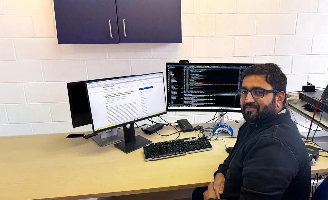 Dr Muhammad Zeeshan Babar sitting at a dsk with PC 