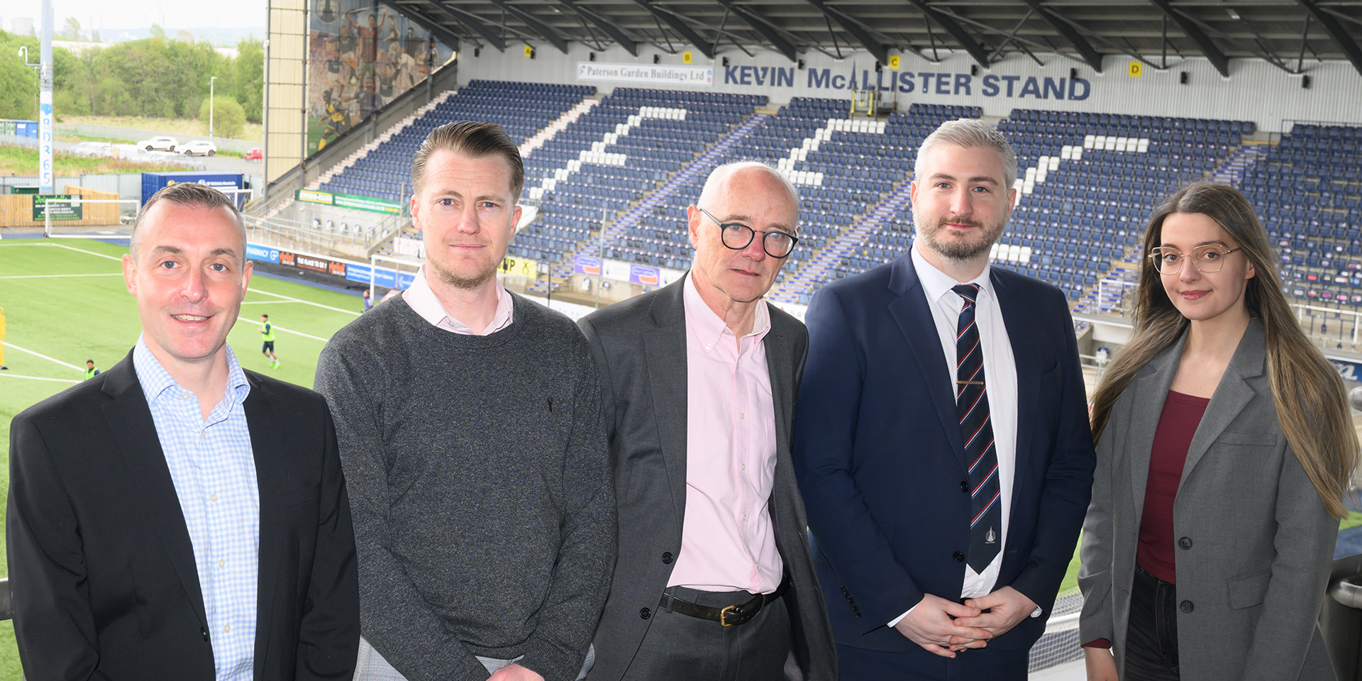 Heriot-Watt University professors and Falkirk Football Club key leaders standing at the stadium. 