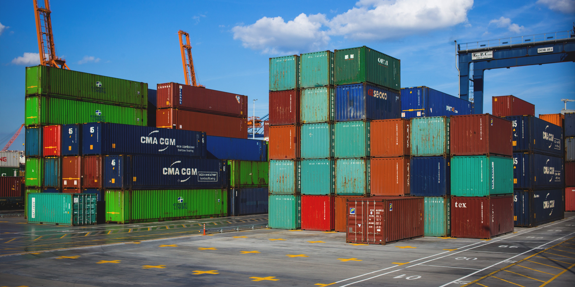 Stacks of shipping containers at a busy port.