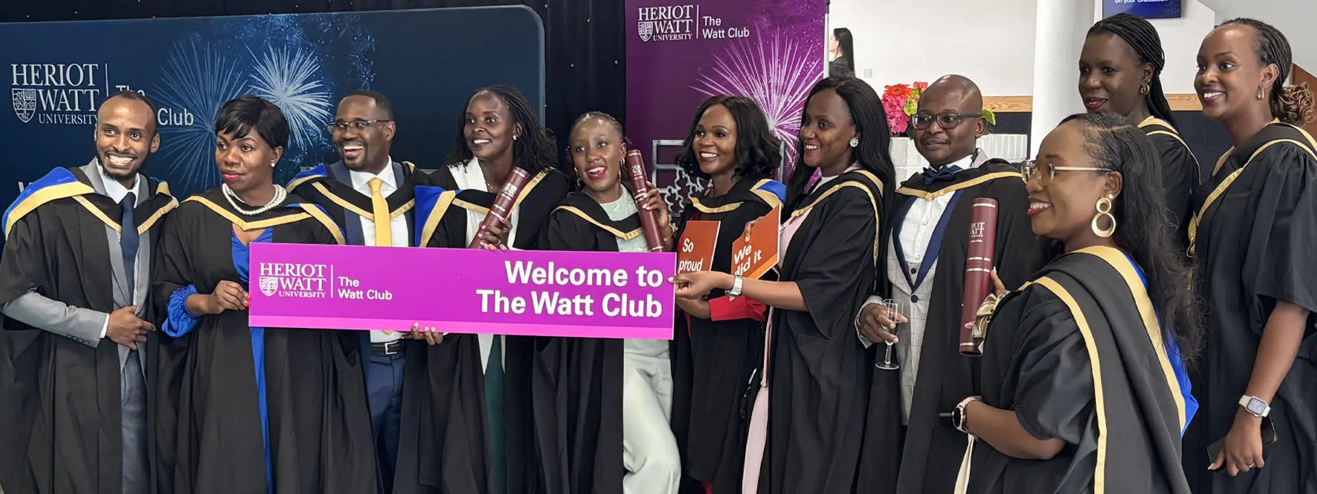 Large group of Heriot-Watt graduates celebrate in front of camera.