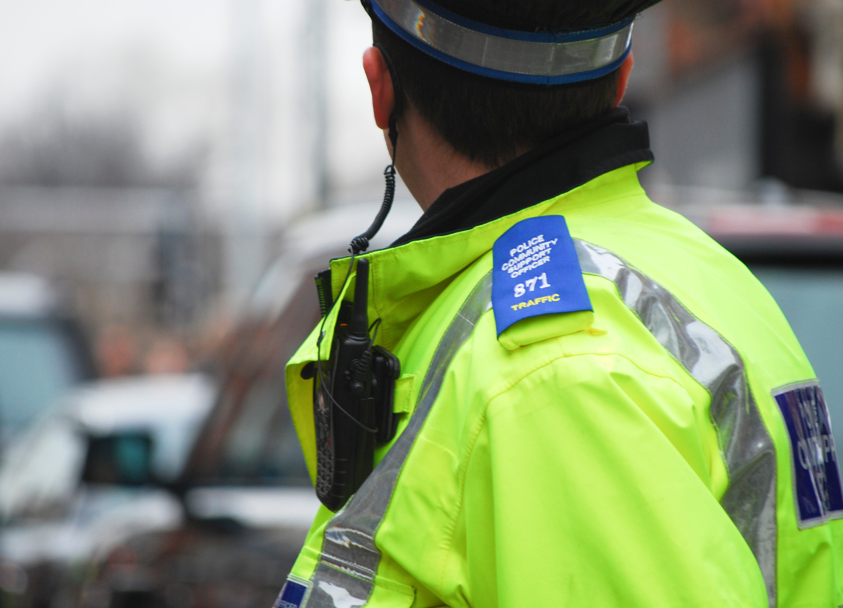 A policeman wearing uniform looks at traffic. 