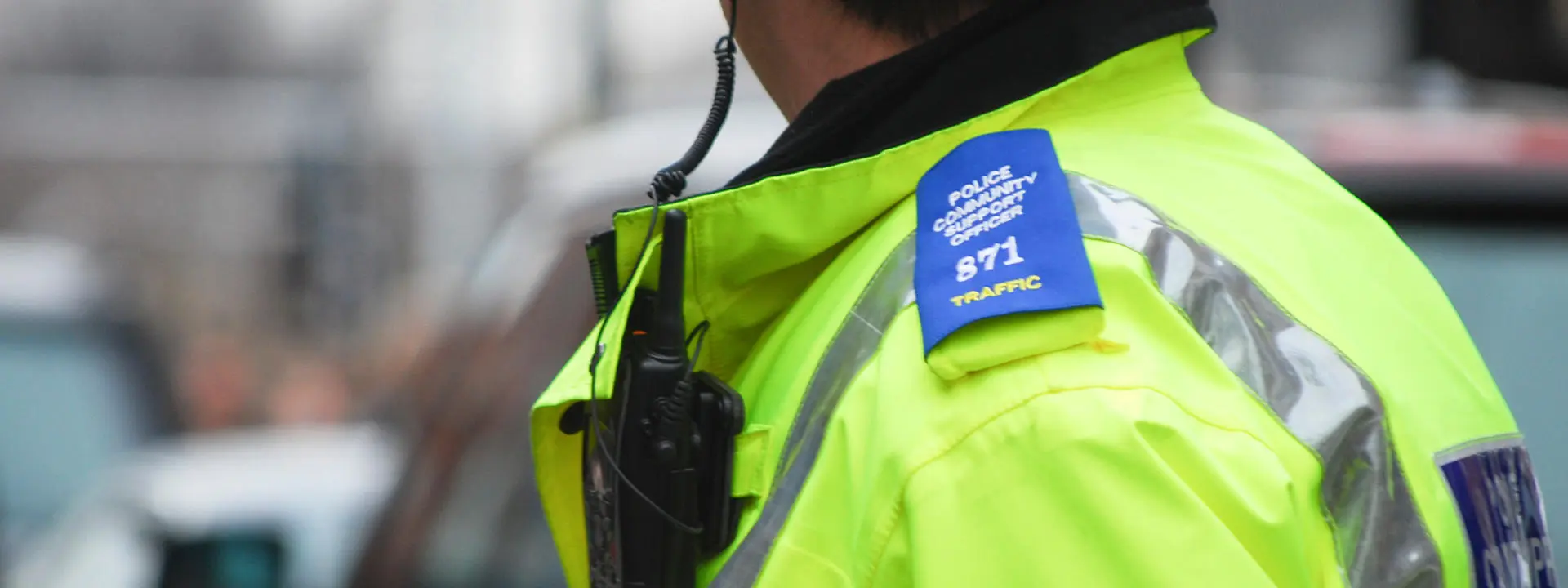A policeman wearing uniform looks at traffic.