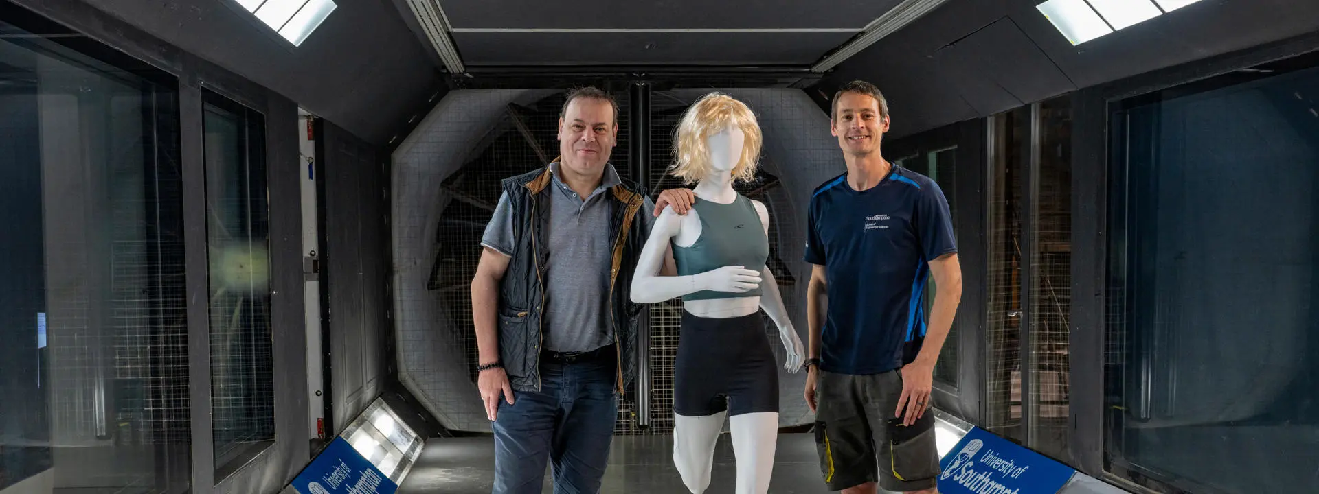 Professor Bert Blocken (left) with Dr David Marshall stand in the wind tunnel with a static test mode between them.