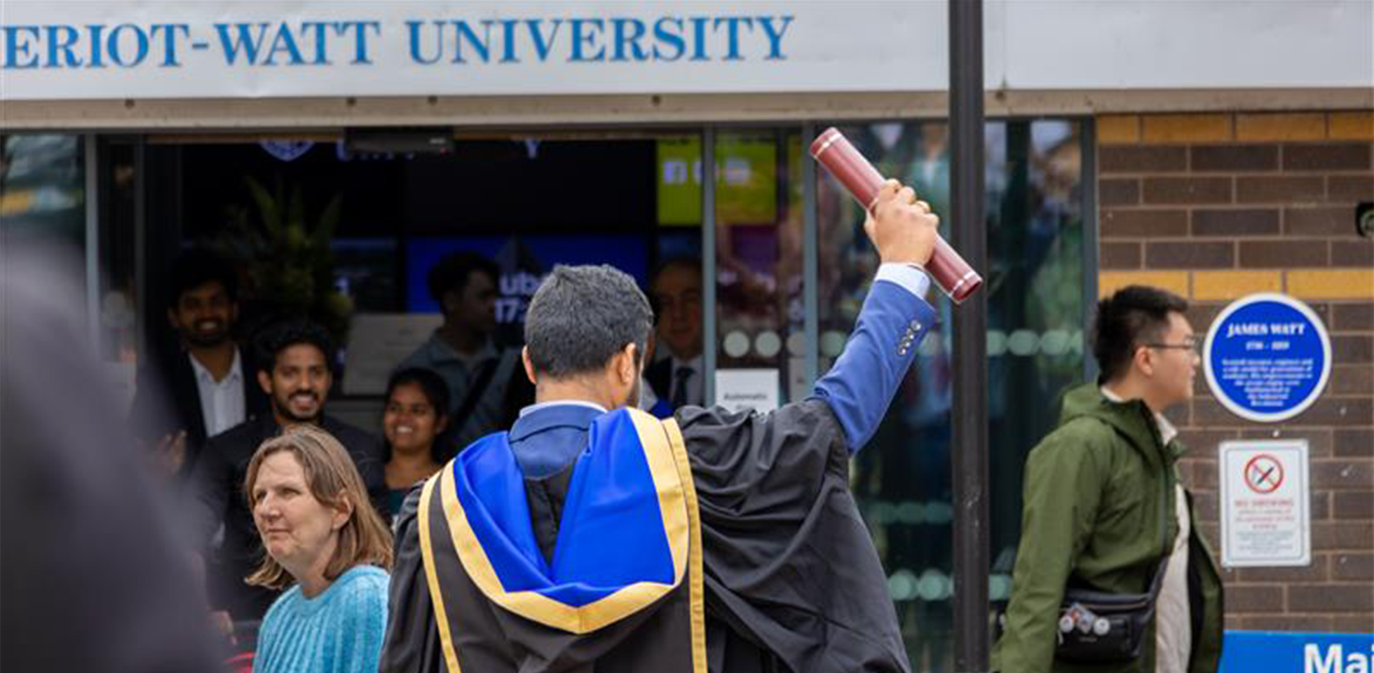 Student holding his scroll.