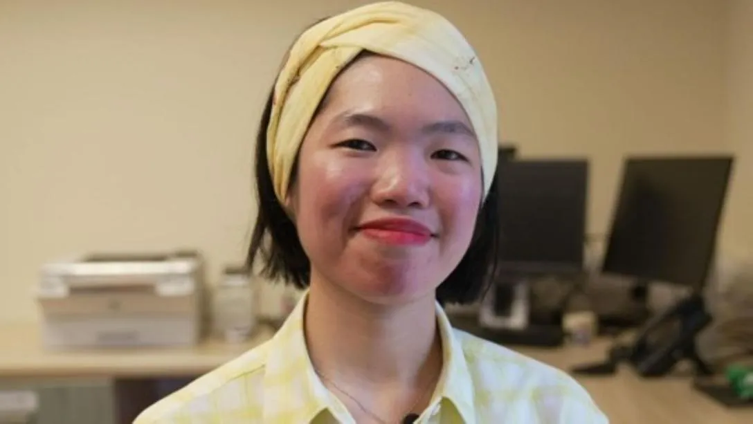 A smiling woman is pictured in an office