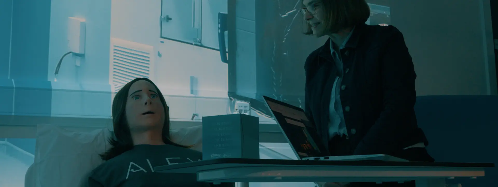 Alex robot in simulated hospital environment with staff performing tests.