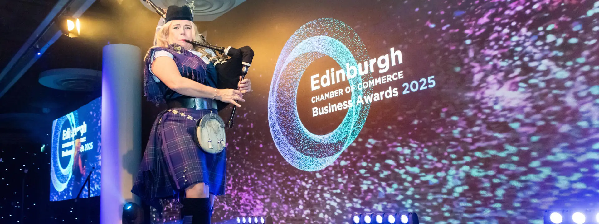 A person playing the bagpipes at an award ceremony.