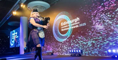 A person playing the bagpipes at an award ceremony.