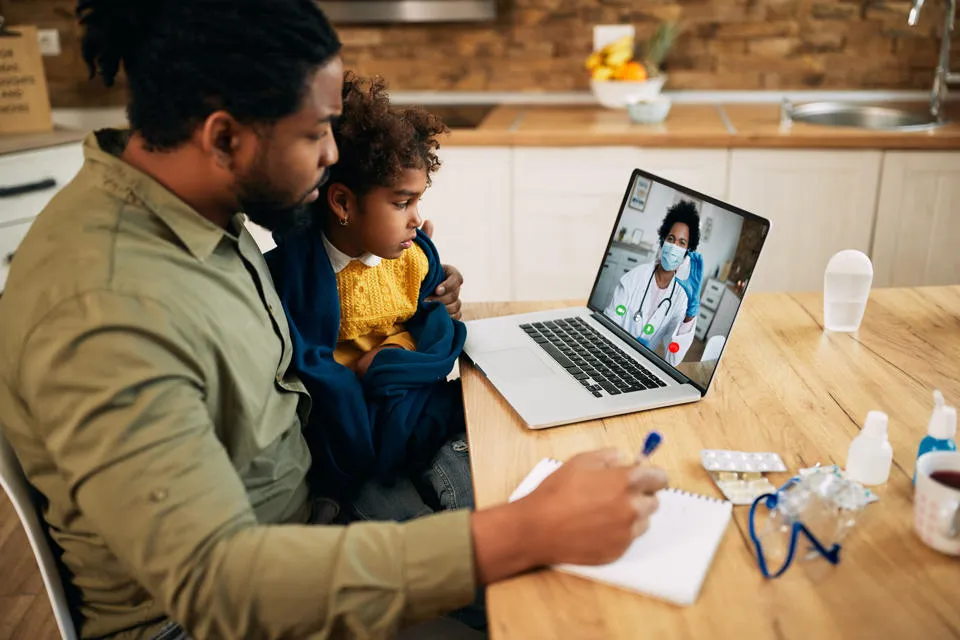 A father and child sitting at a computer. Researchers found that poorly designed digital platforms could further marginalise vulnerable groups.
