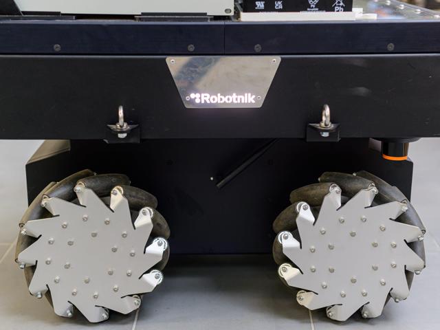 This image shows a close-up view of a Robotnik-brand robotic platform with mecanum wheels.