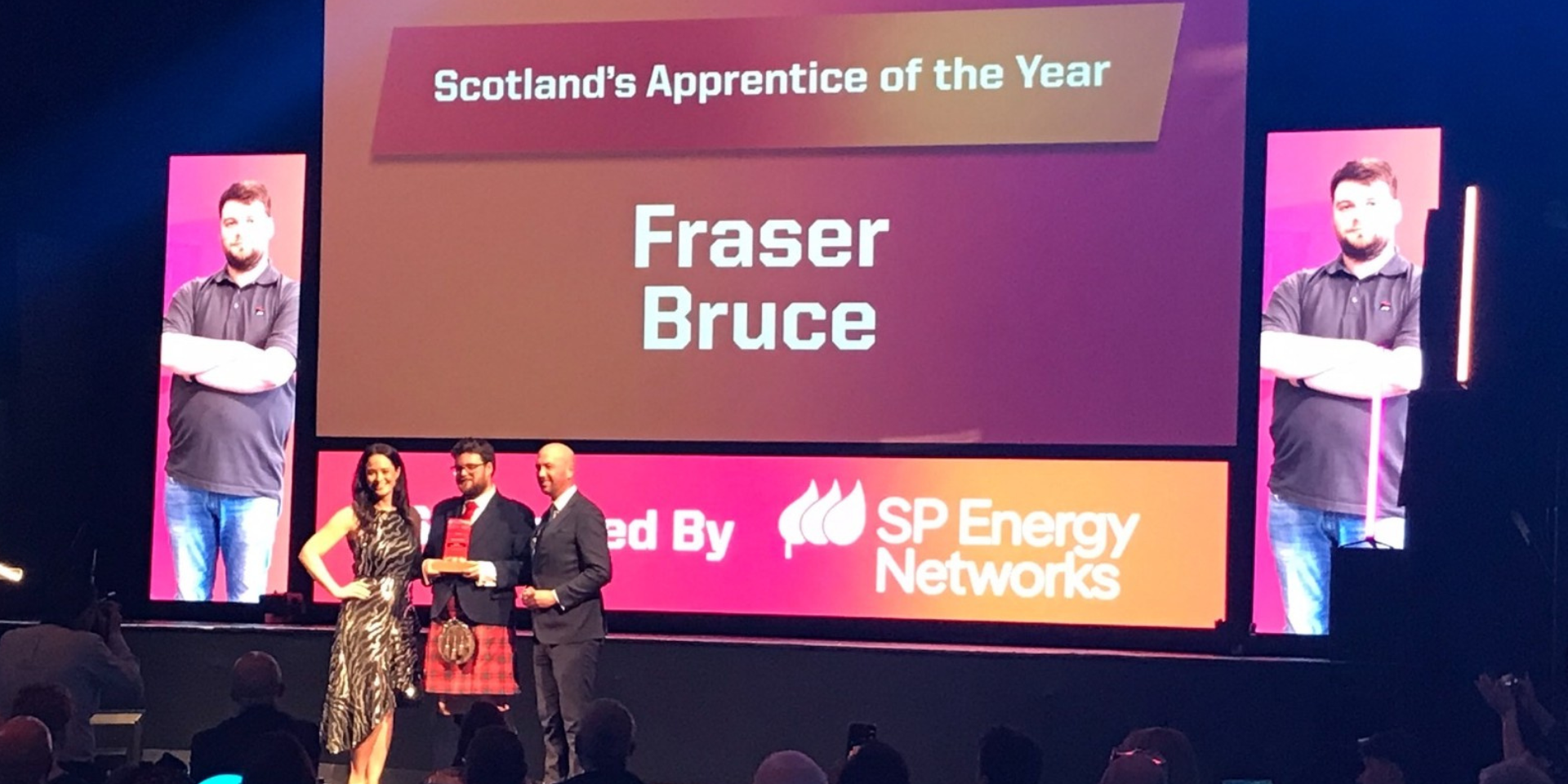 Fraser Bruce onstage at the awards ceremony receiving his award.
