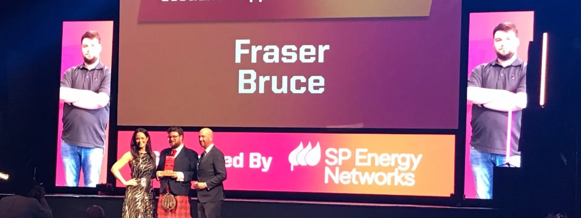 Fraser Bruce onstage at the awards ceremony receiving his award.