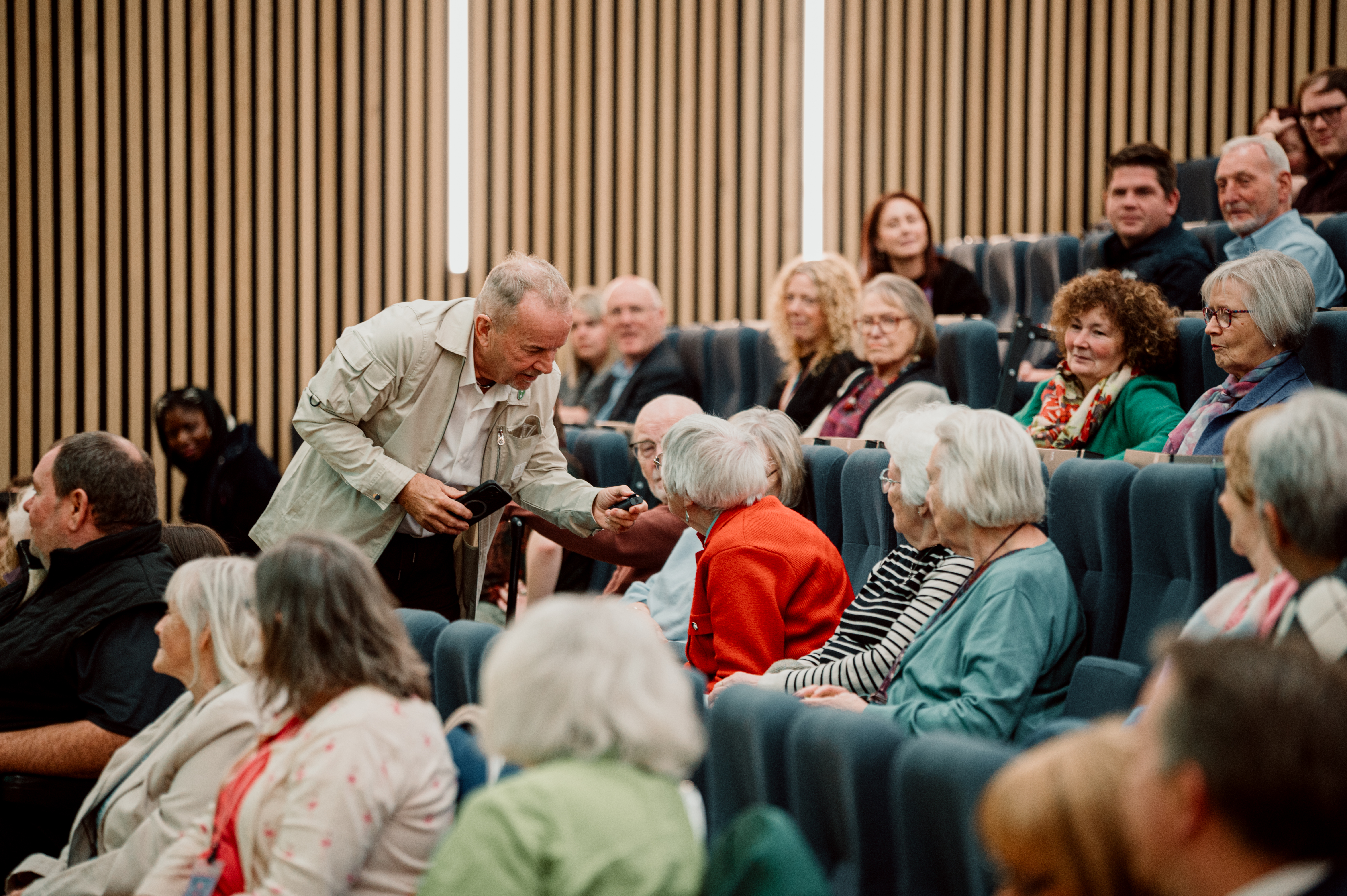 People in a crowd speaking with the presenter.
