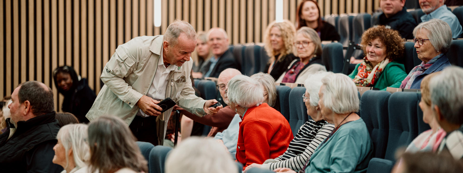 People in a crowd speaking with the presenter.