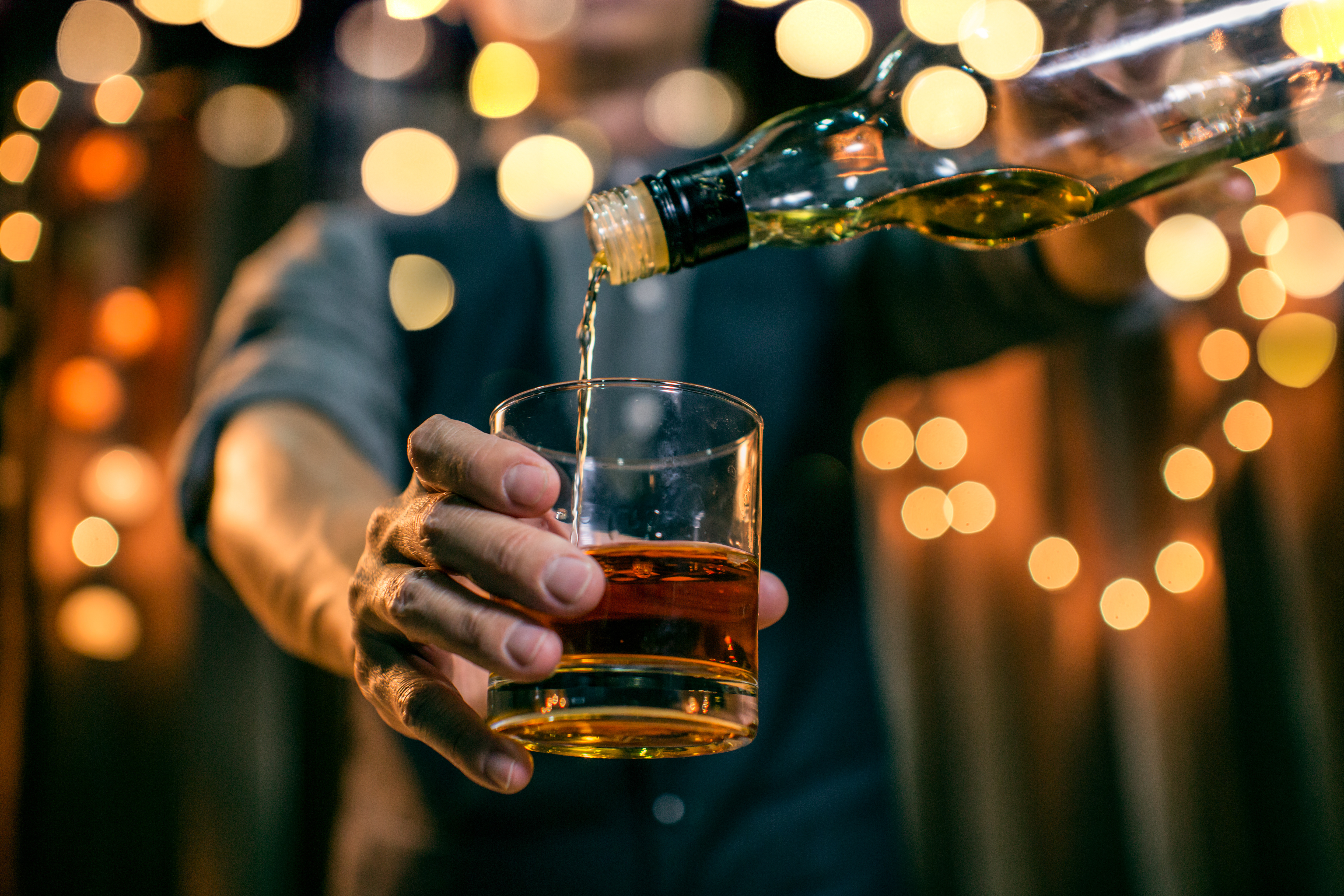 A glass of whisky being poured