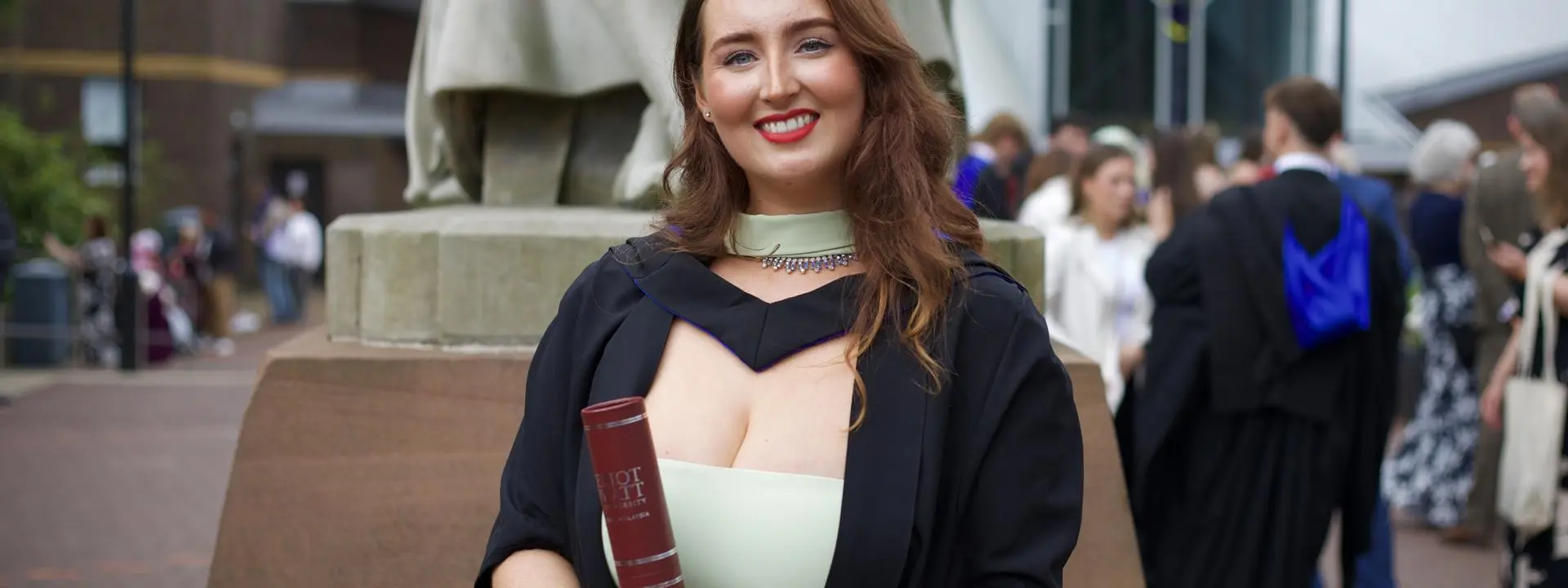 Picture of Caitlin Cummings standing with her scroll.