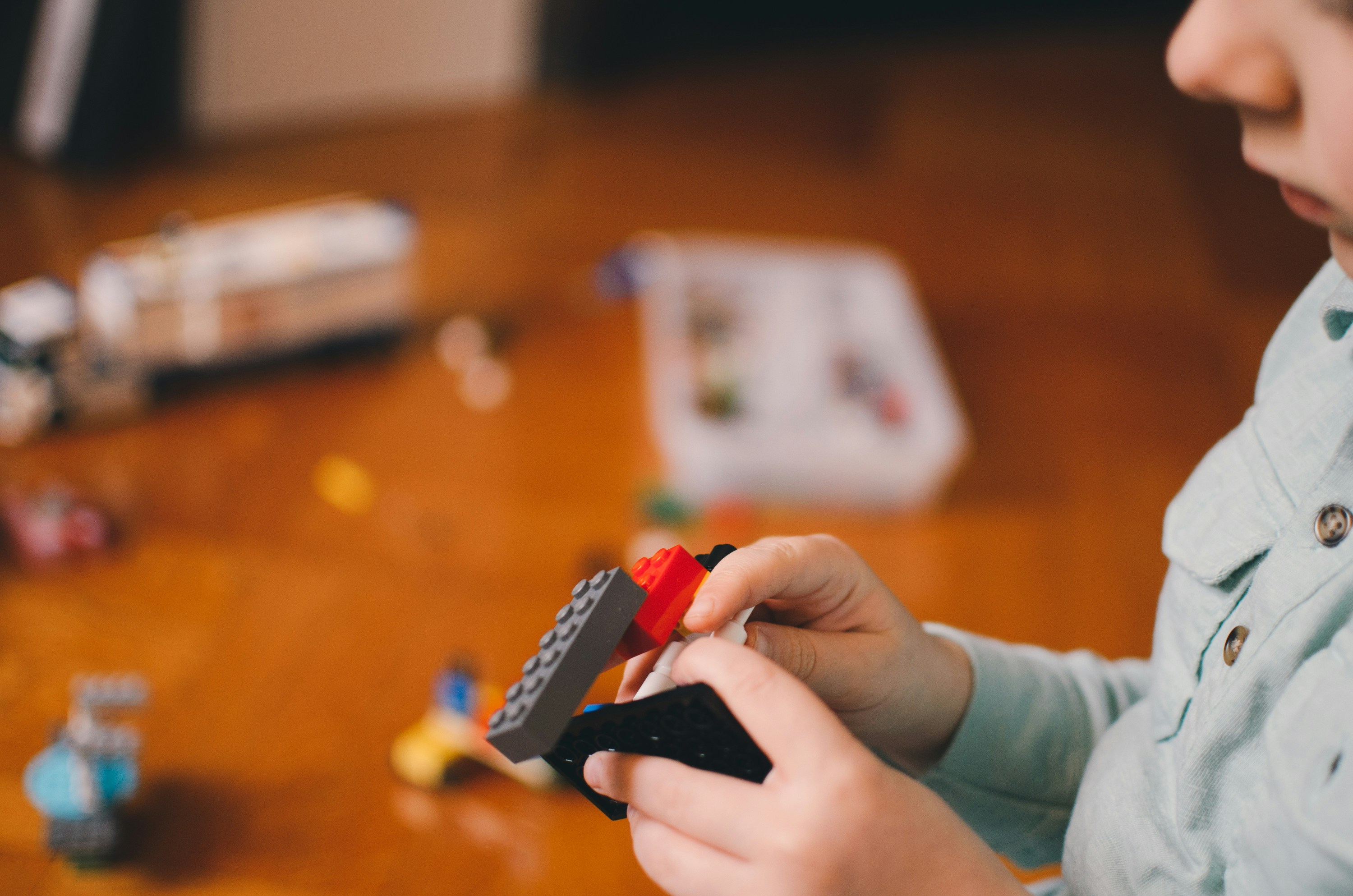 Image shows a child's hands playing with Lego. 