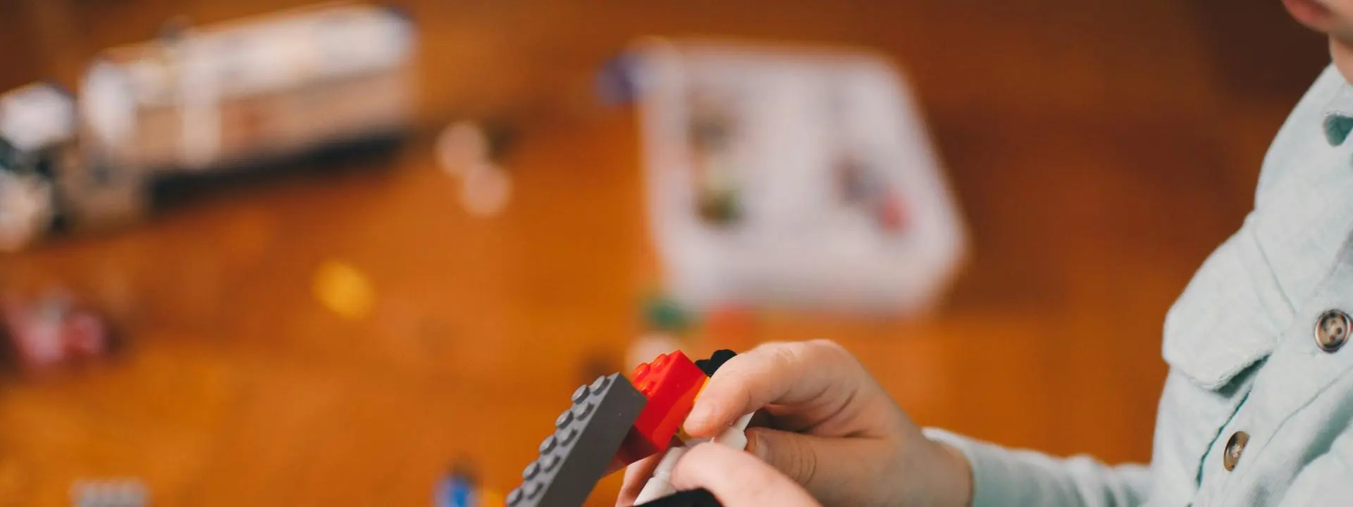 Image shows a child's hands playing with Lego.
