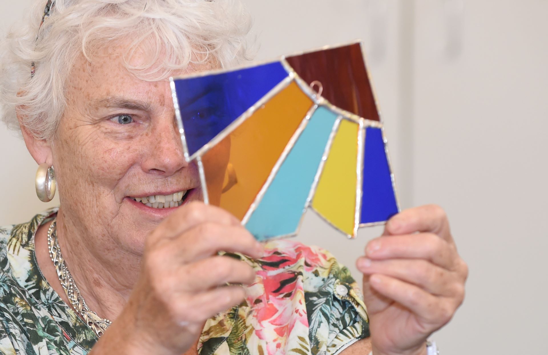 Participant looking through stained glass made at Ageing Lab workshop