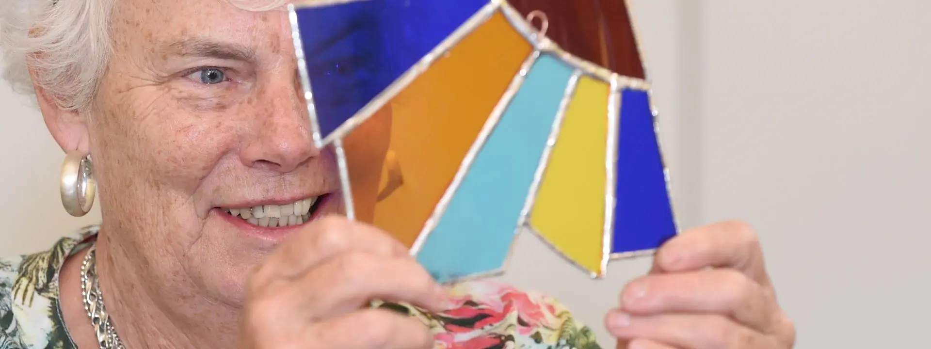 Participant looking through stained glass made at Ageing Lab workshop