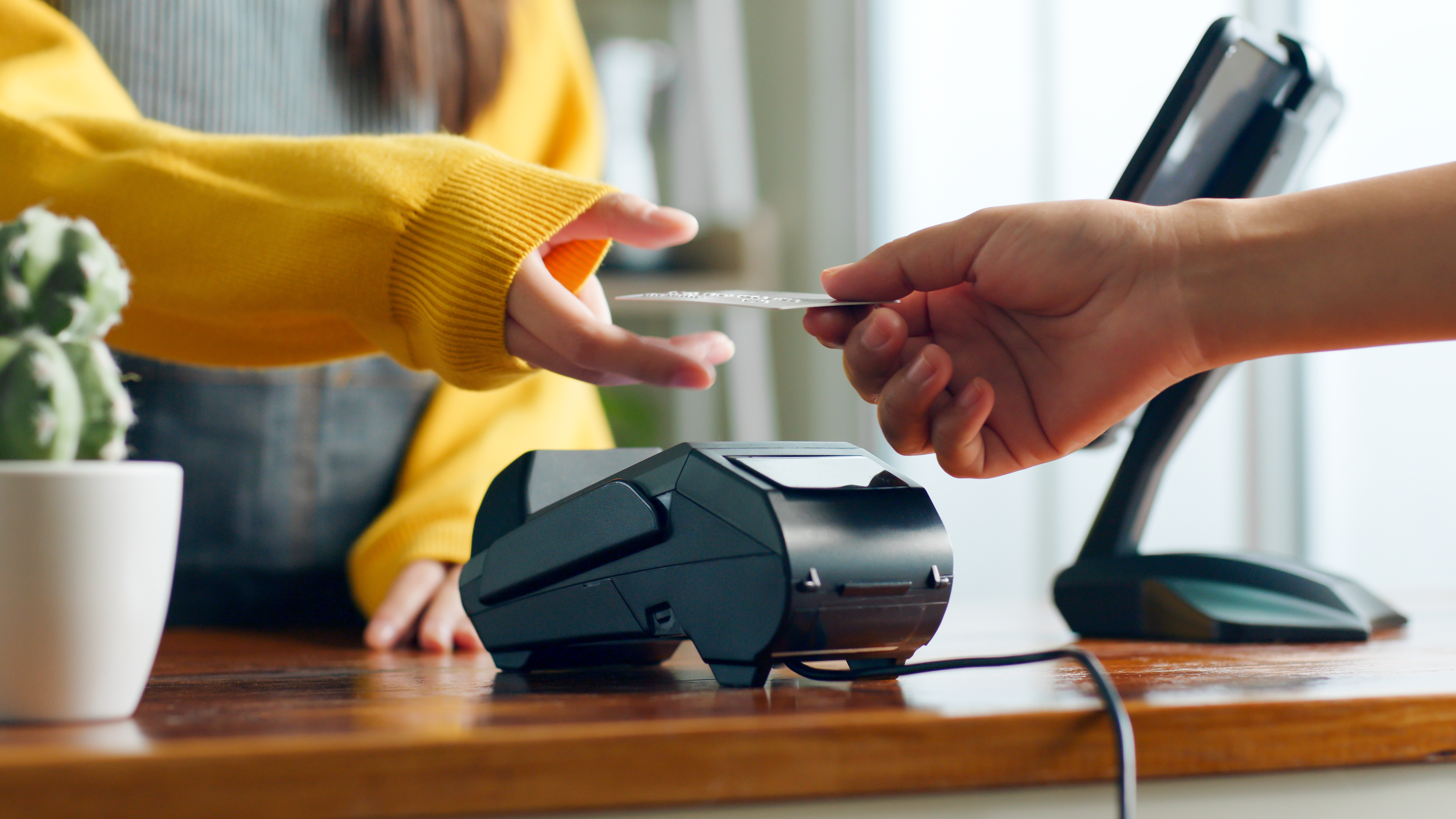 Customer using credit card for payment to owner at cafe restaurant