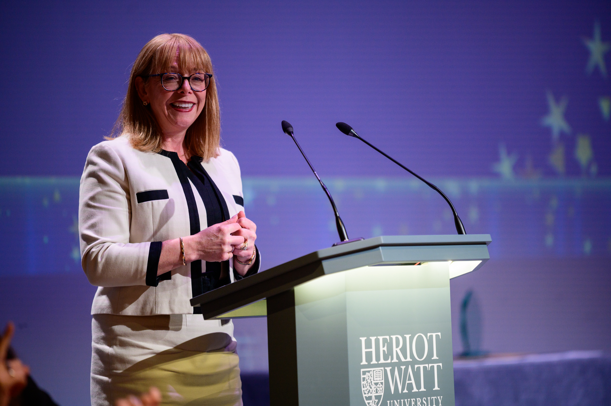 Principal Nola Hewitt-Dundas standing at a podium at Heriot-Watt University 