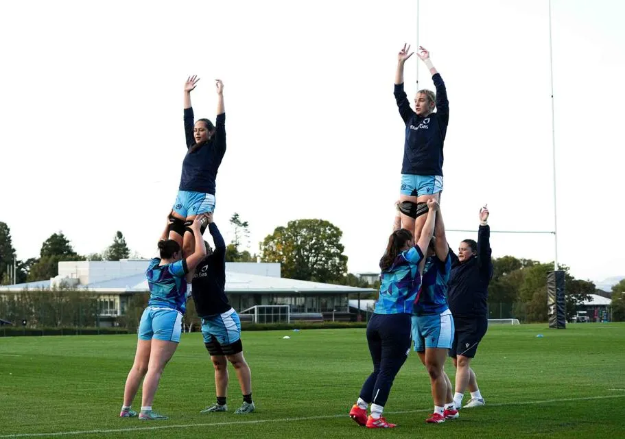 Women rugby players team training on pitch
