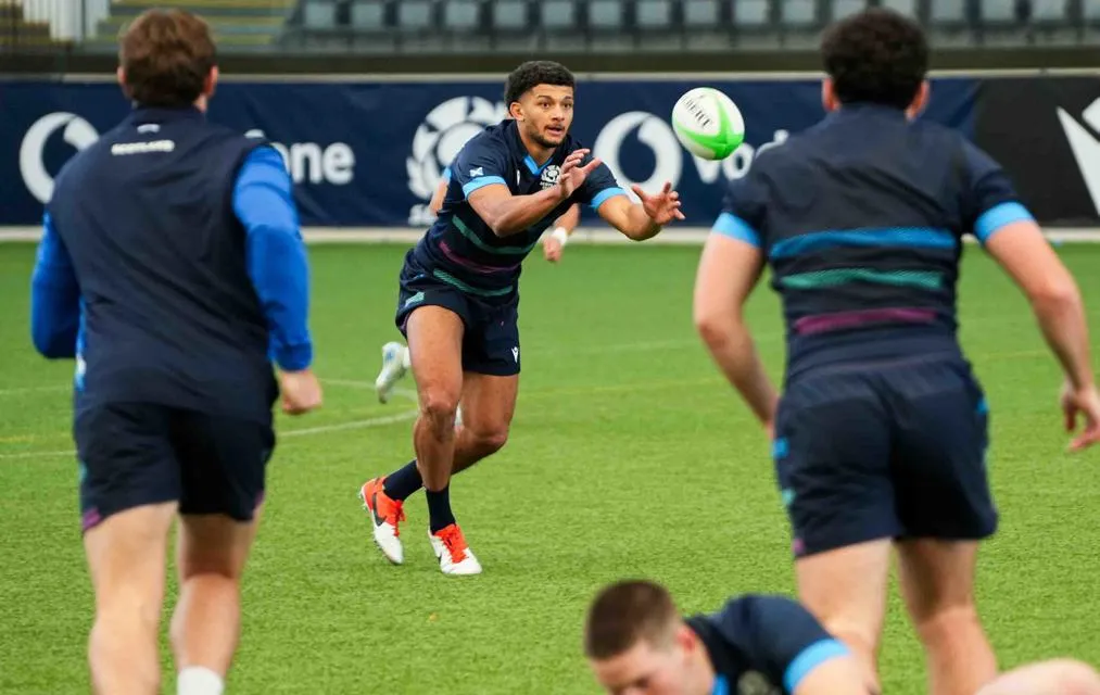 Rugby players pass the ball on pitch