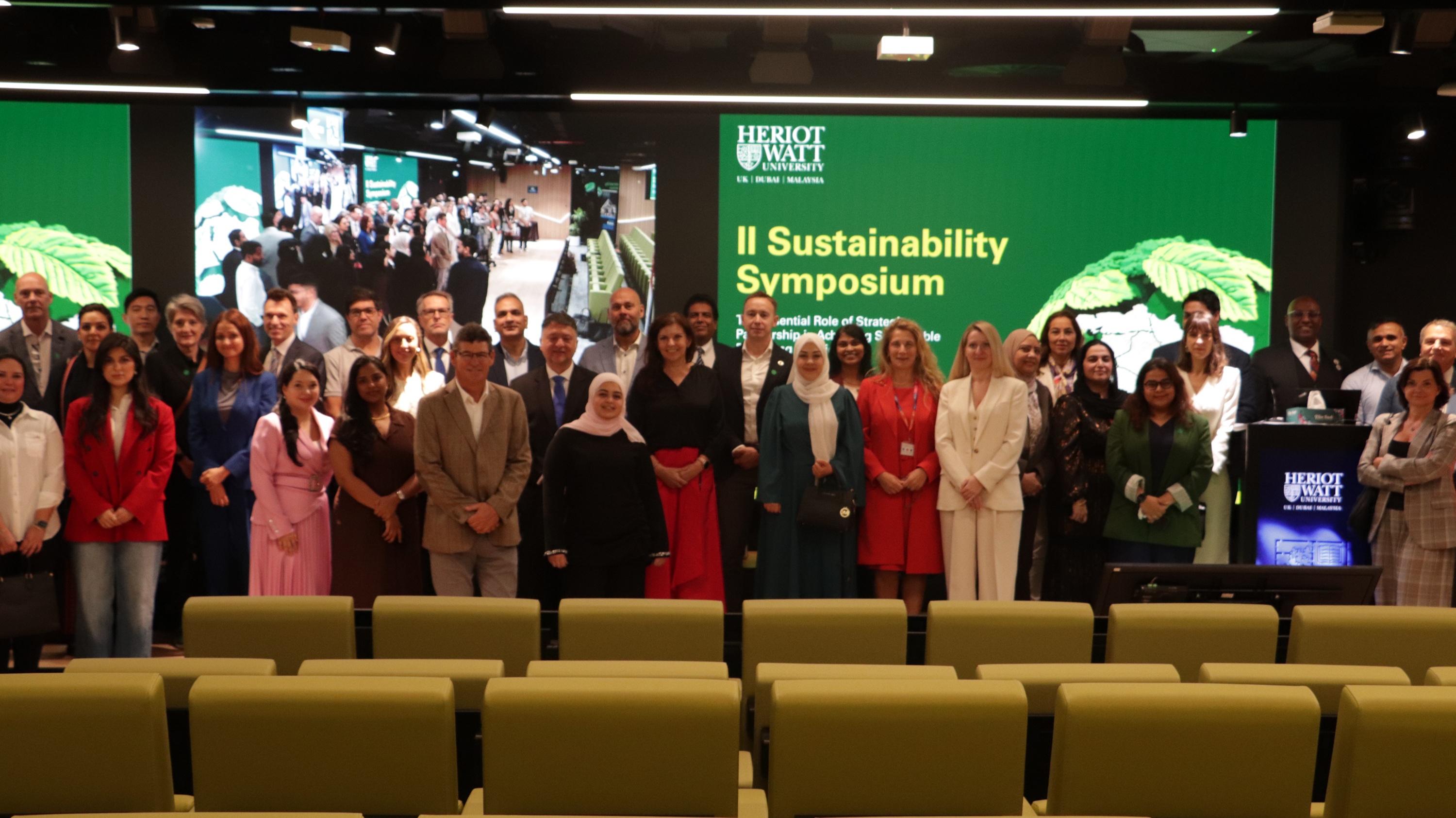 group of people standing infront of digital wall standing for a group photo
