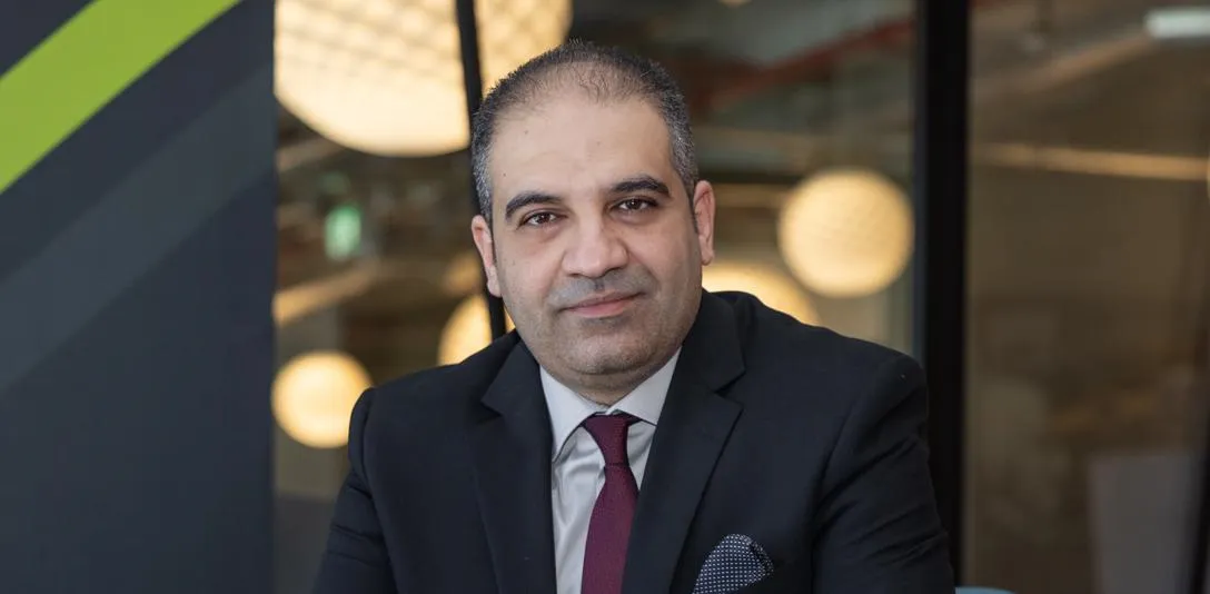 Professor Hani Ragab Hassen in a black suit with a white shirt and a maroon tie