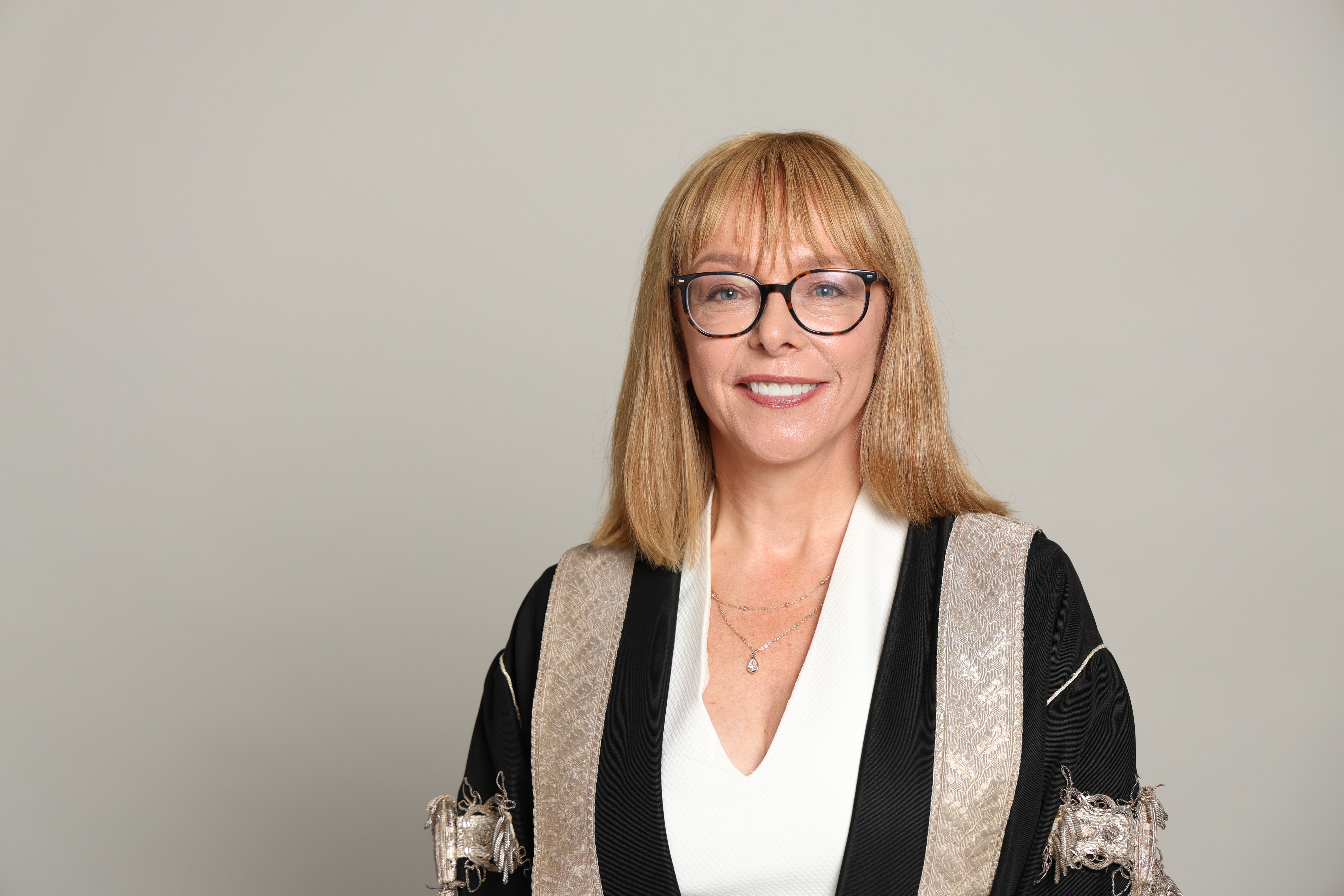 A portrait image of Professor Nola Hewitt-Dundas, Principal and Vice-Chancellor of Heriot-Watt University wearing a dark silver and black robe