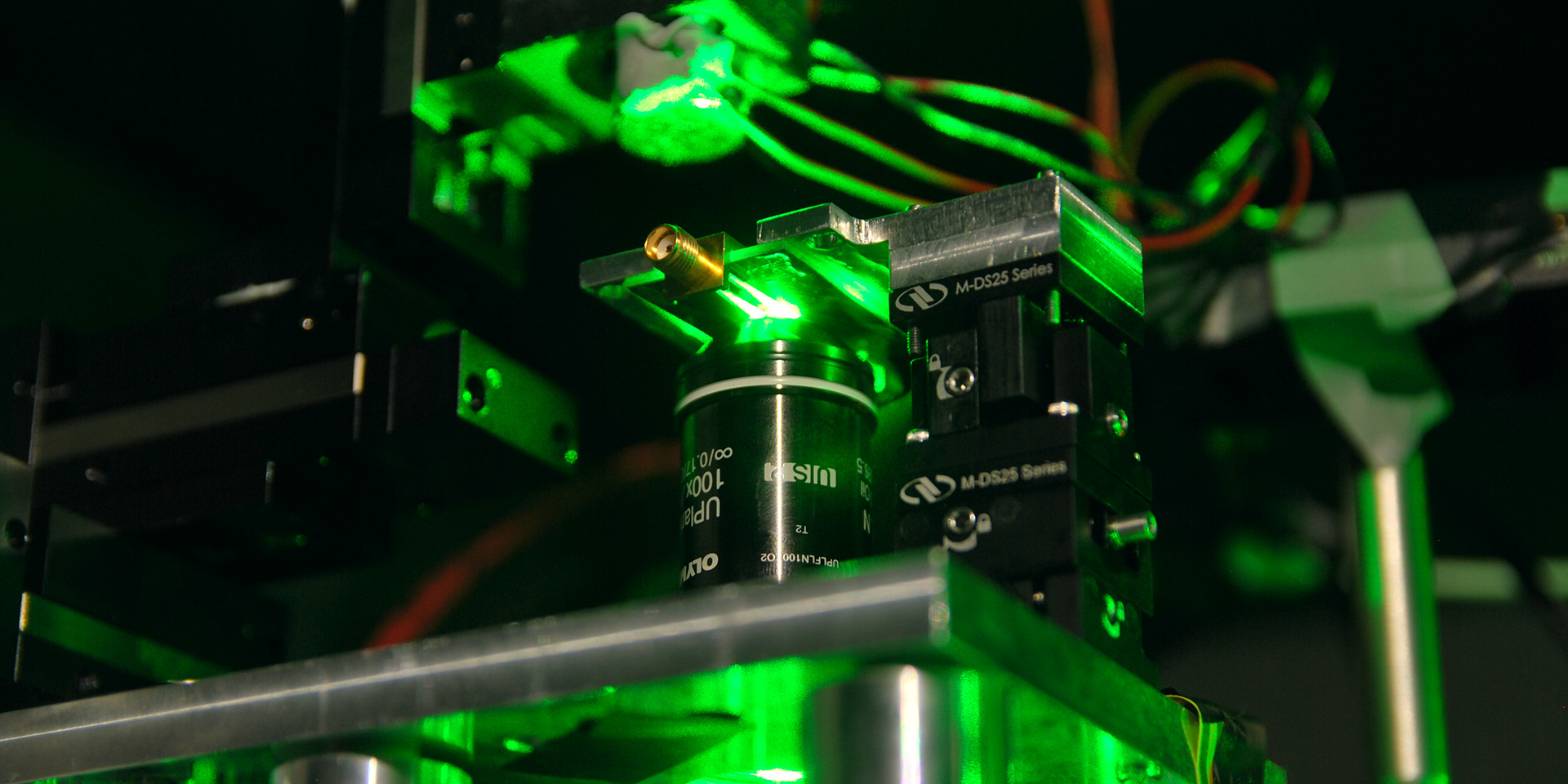 Close-up of equipment in Quantum laboratory at Heriot-Watt University with parts of the equipment showing a green light 