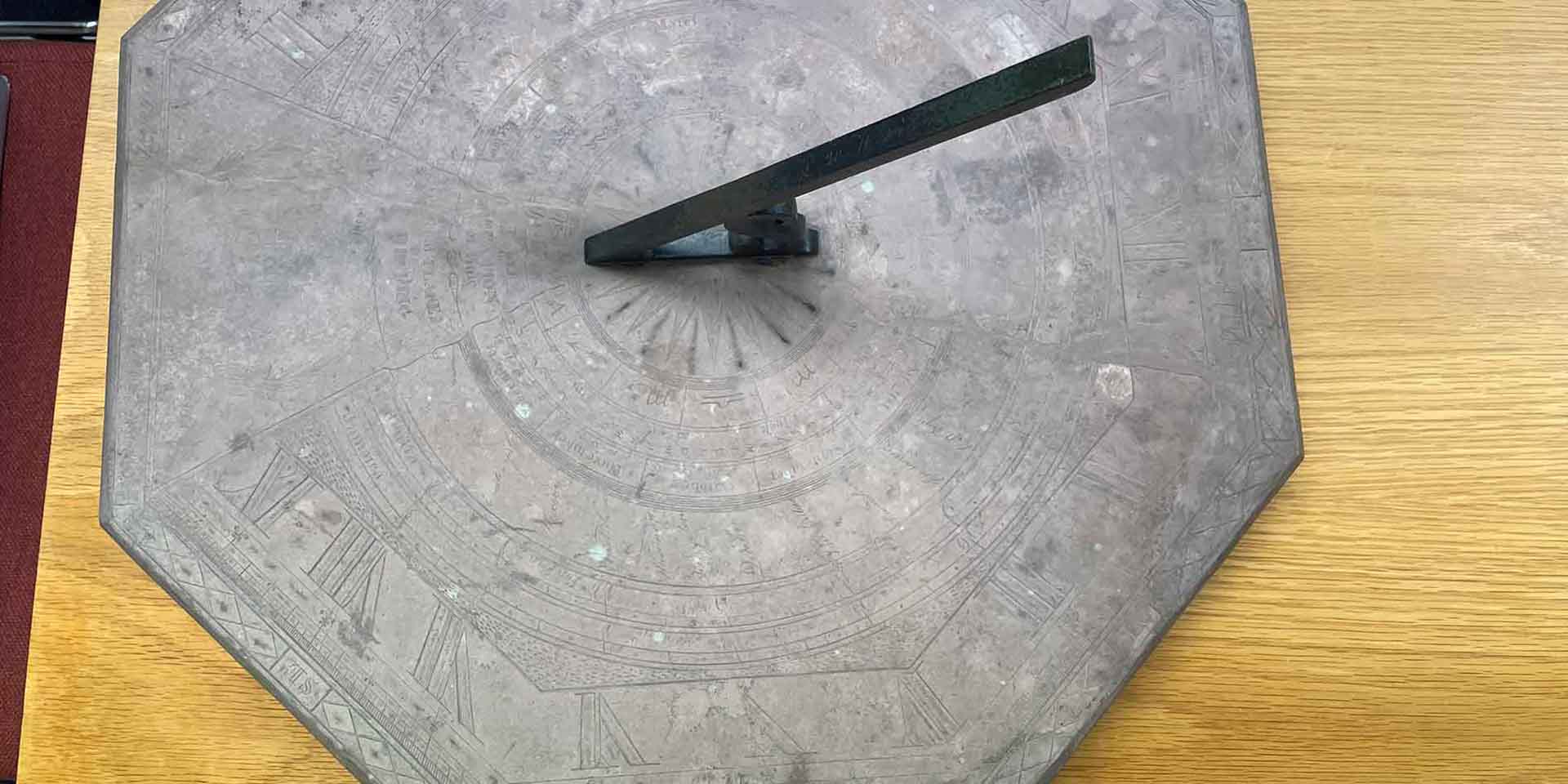 Large octagonal stone sundial with roman numerals and markings