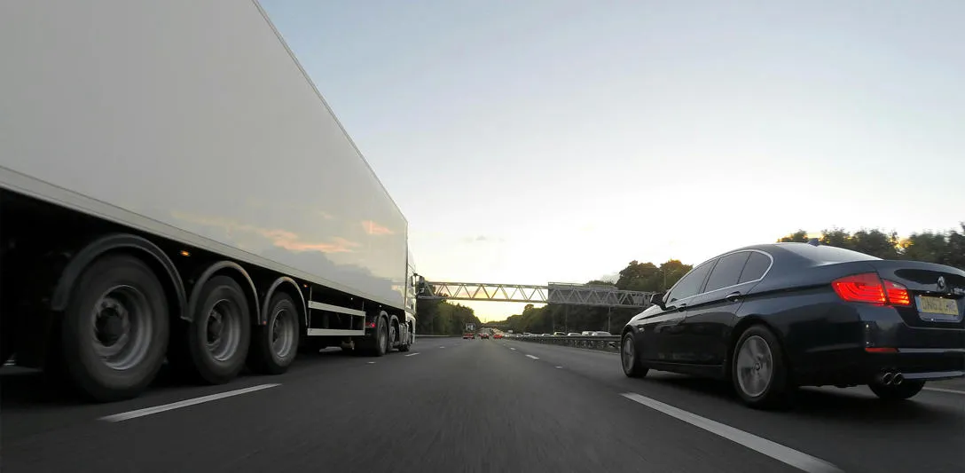 A truck and car on a motorway. Photo by Mike Bird, Pexels.