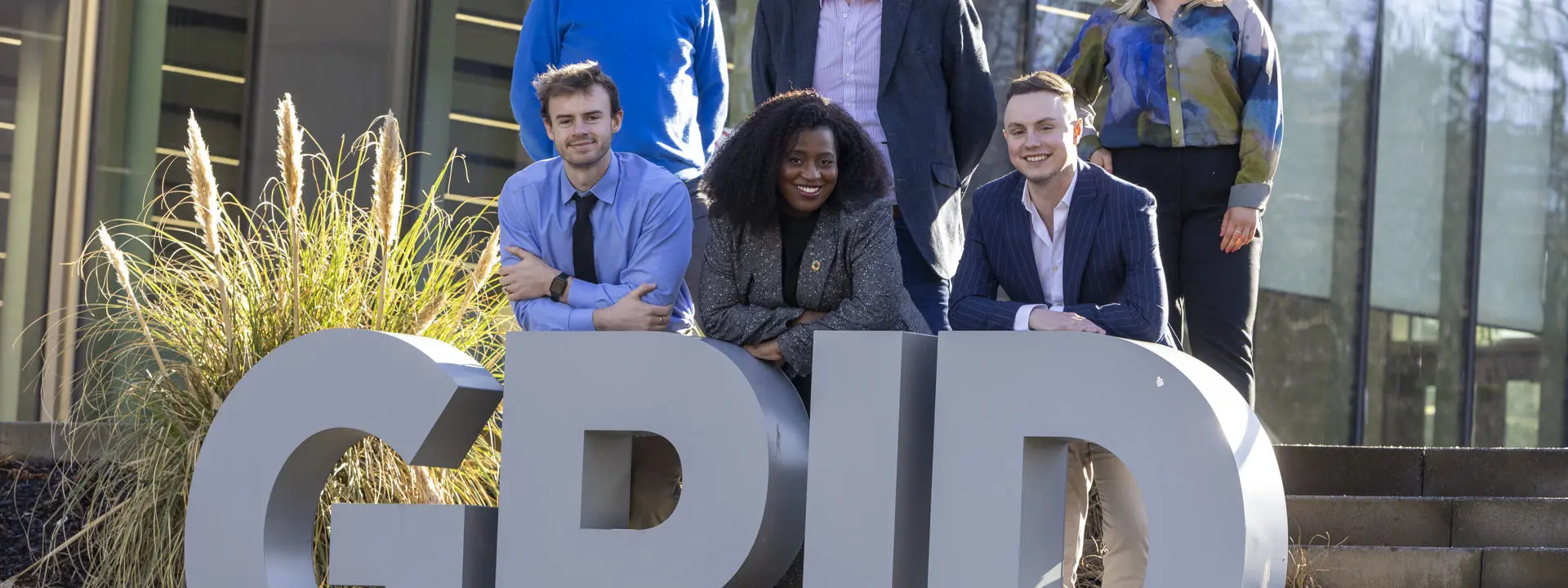 Heriot-Watt and CGI stakeholders stand behind the university's Heriot-Watt's Global Research Innovation Discovery sign