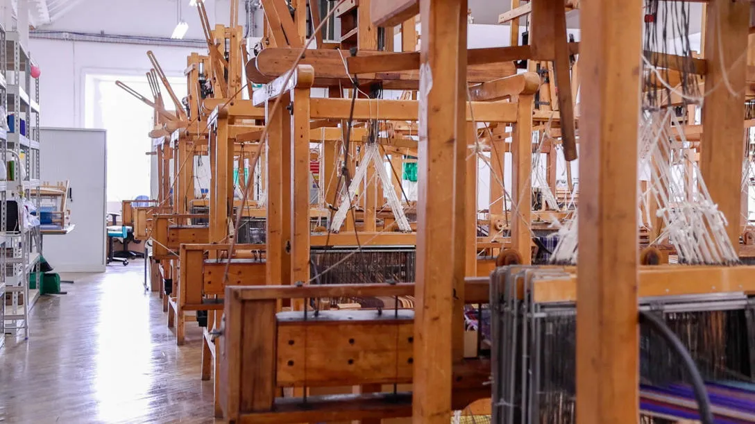 Line of large standing looms in workshop