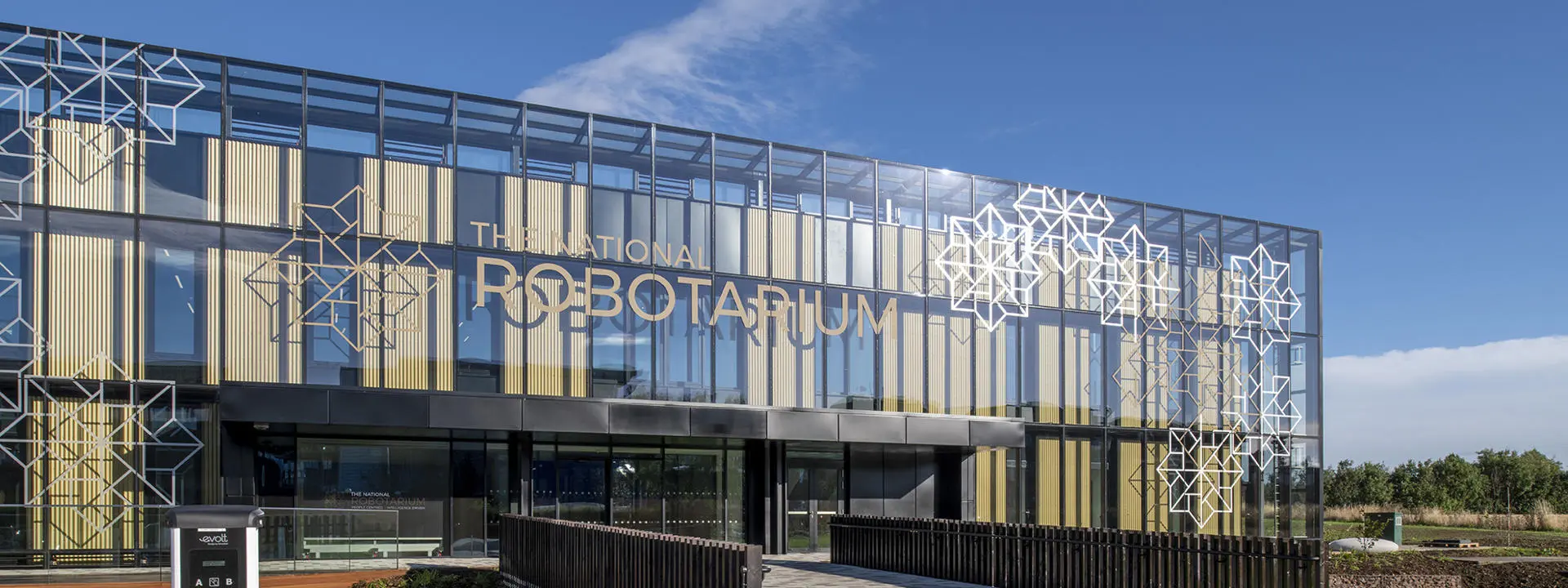 a modern building with a glass facade and geometric patterns on the exterior