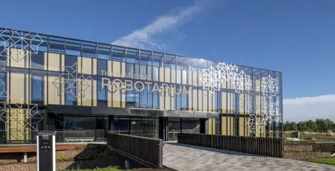 a modern building with a glass facade and geometric patterns on the exterior