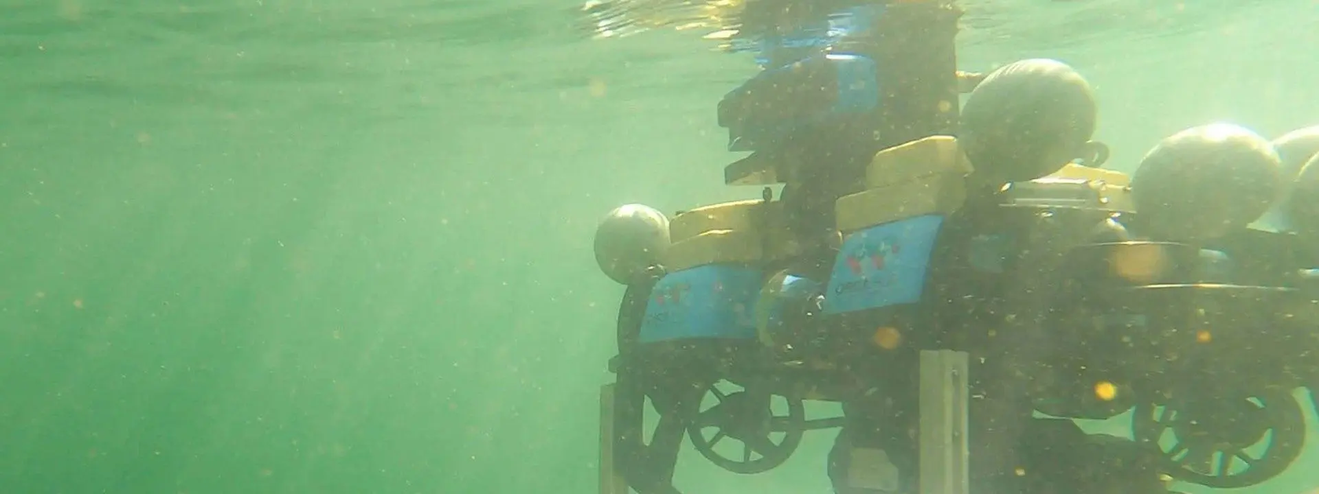 Surface vessel and autonomous underwater robot undergoing trials in Heriot-Watt University's wave tank facility